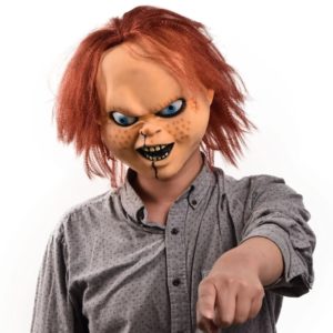 Masque de Chucky porté par un homme portant une chemise et qui pointe du doigt devant lui