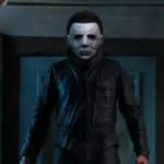 Homme debout habillé en noir portant le masque du film Michael Myers
