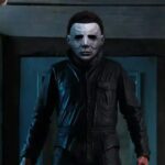 Homme debout habillé en noir portant le masque du film Michael Myers