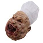 Image d'un masque représentant un homme avec une toque de cuisinier, la bouche en sang et ridé