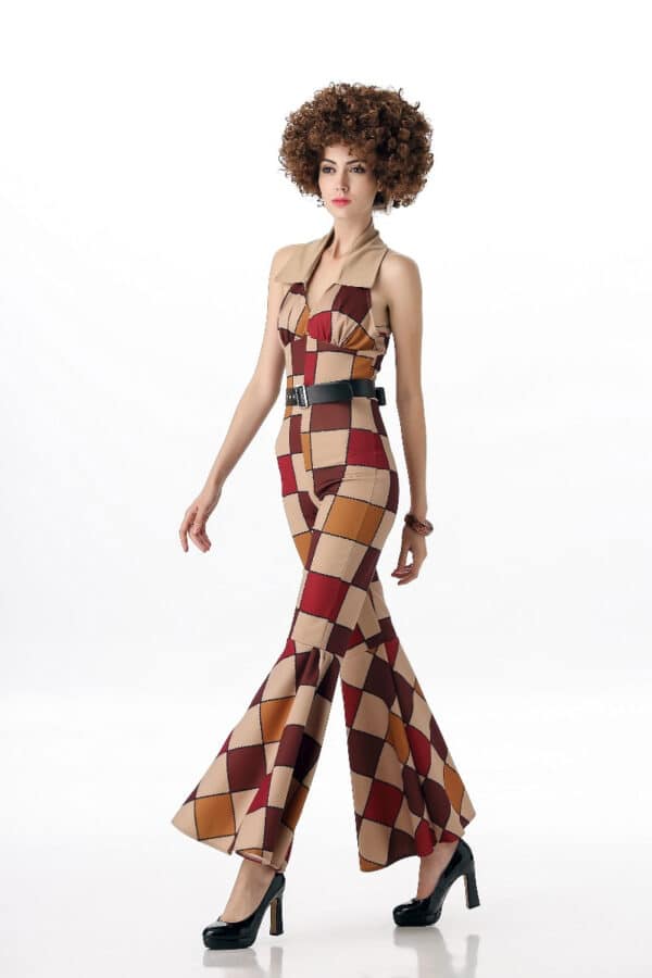 jeune femme brune avec coupe afro, porte un déguisement , une combinaison style disco à carreau dans les tons beiges, avec une ceinture noire, pantalon bouffant et manches courtes, présentée sur fond blanc