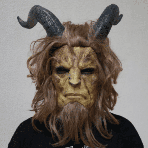 Masque de la Bête marron avec de longs cheveux et barbe, avec deux cornes sur la tête, porté par un homme de face