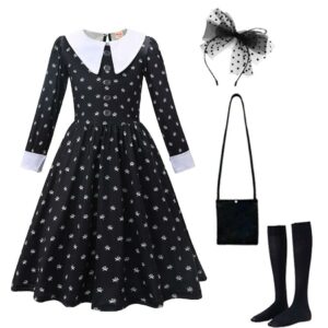 La robe classique de Mercredi Addams, évasée et au cul blanc, à côté un serre-tête noir, un sac à bandoulière noir et des chaussettes noires, le tout sur un fond blanc.