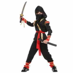Enfant portant le costume de Ninja pour enfant, il est noir et rouge et comprend une tunique, un pantalon, une capuche, une ceinture, un masque et 4 rubans dorés, sur fond blanc