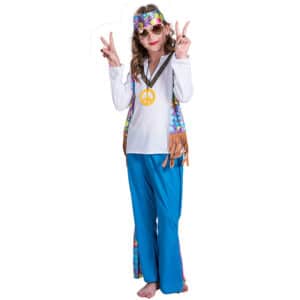 Une fille déguisée en hippie sur un fond blanc. Son déguisement se compose d'une chemise blanche avec le col en V, une fausse veste au motif de fleurs et avec une frange au bas, un pantalon bleu avec des détails fleuris au même motif que la fausse veste et un bandeau au même motif de la fausse veste.