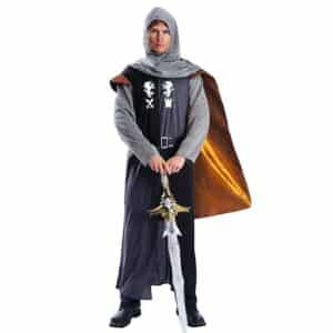 Un homme pose en déguisement de chevalier médiéval. Le costume est composé d'une cagoule en imitation de cotte de maille, d'une tunique longue noire avec blason blanc et ceinture ainsi que d'une cape dorée. Il porte également un pantalon noir et tient une épée dans les mains
