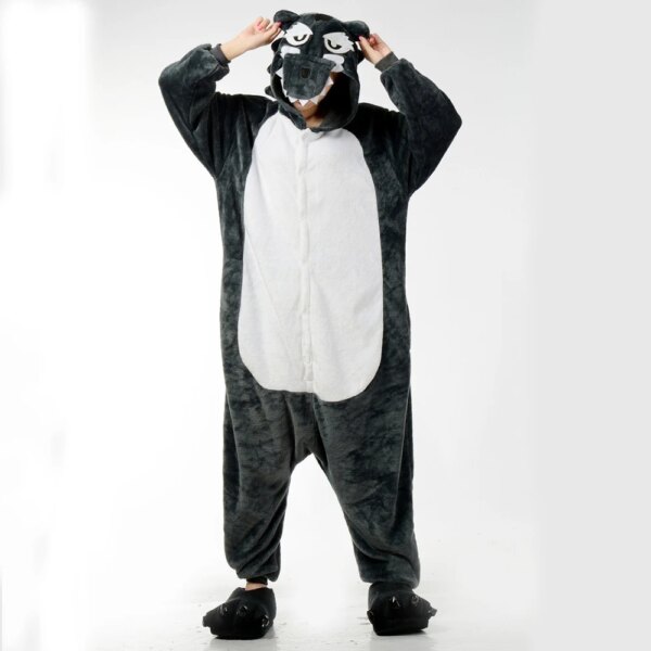 Femme portant le déguisement cosplay de loup gris pour adulte qui se compose d'une combinaison douce avec une capuche en forme de tête de loup et une queue à l'arrière, sur fond blanc.