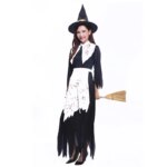 Femme portant le costume de sorcière ensanglantée pour femme se composant d'une longue robe noire et blanche tachée de sang et un chapeau pointu noir, sur fond blanc.