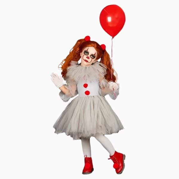 on voit sur un fond clair une petite fille rousse déguisée en clown effrayant du film ça elle tient un ballon rouge de baudruche dans les mains